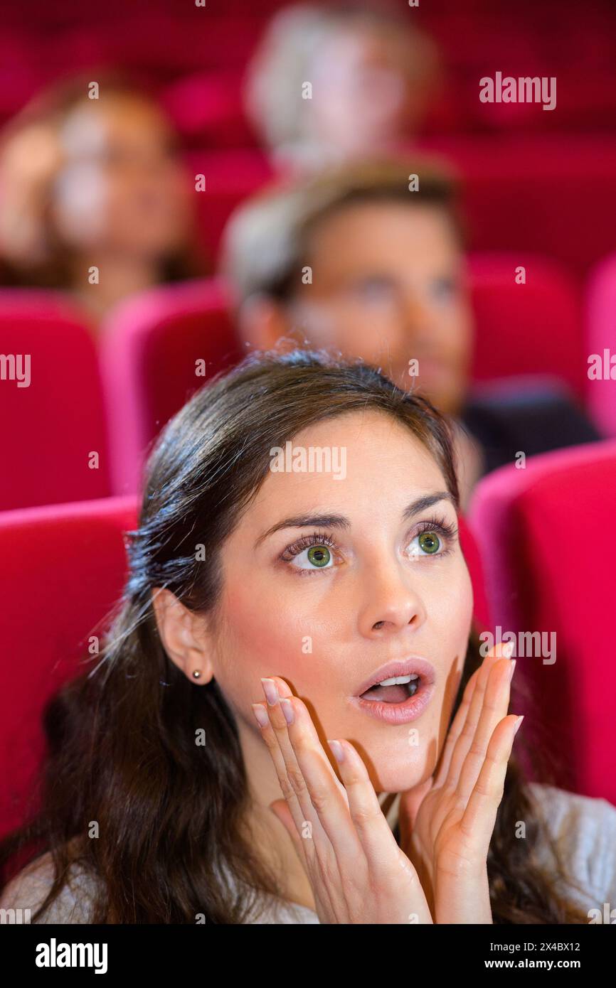 woman engrossed in cinema film shocked expression on her face Stock ...