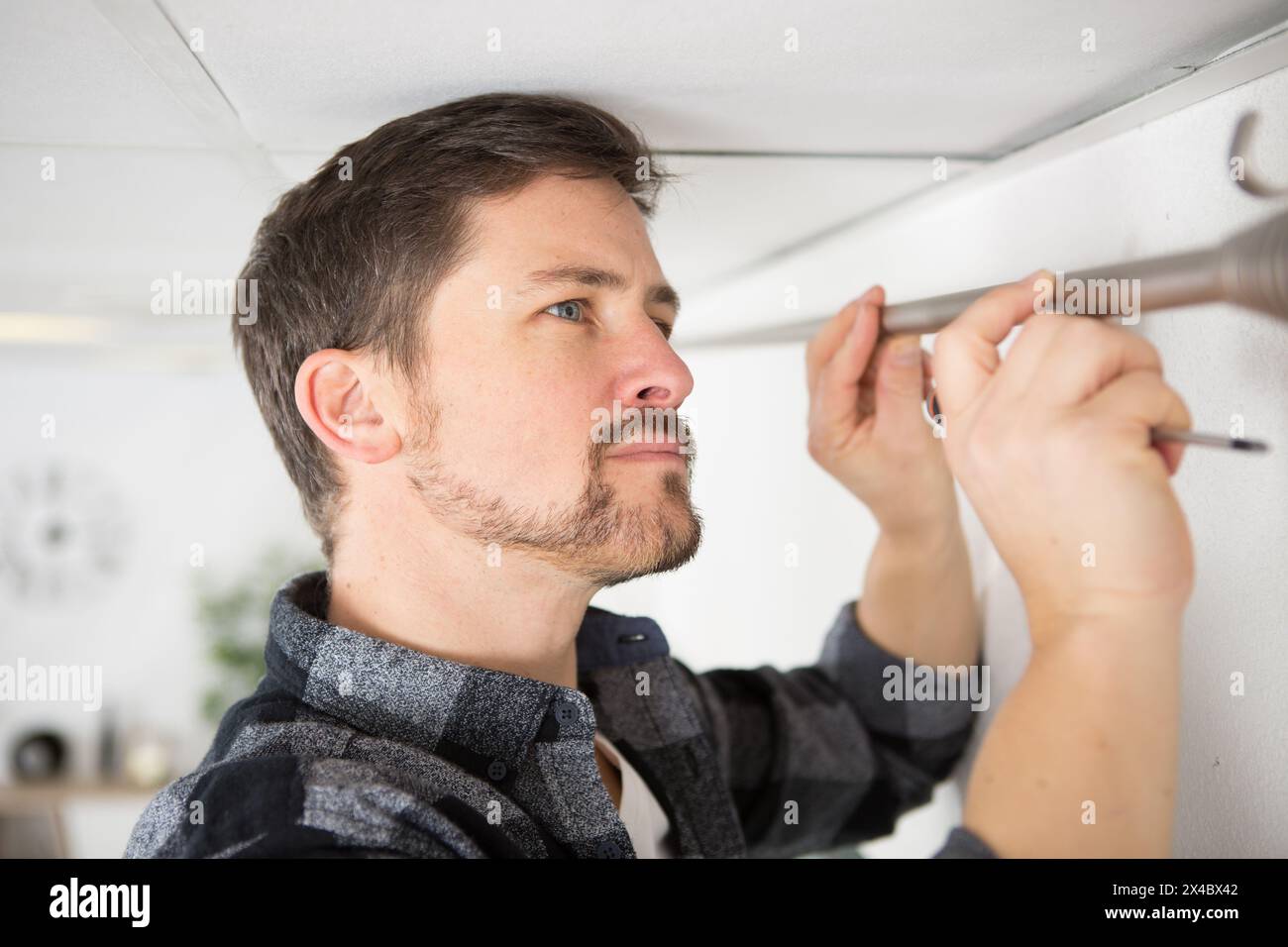 man mounting a curtain rail Stock Photo