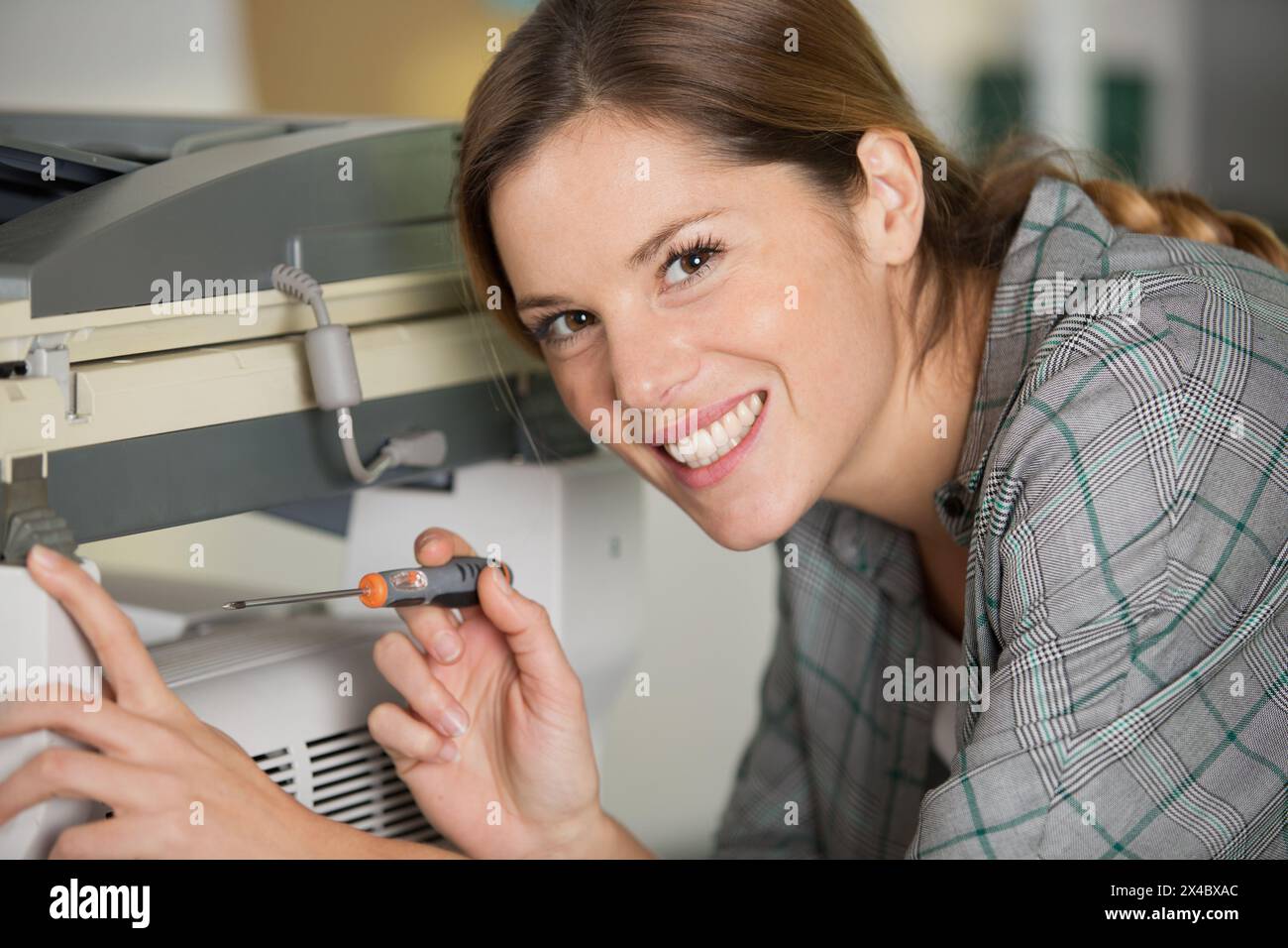 happy woman is fixing a printer Stock Photo