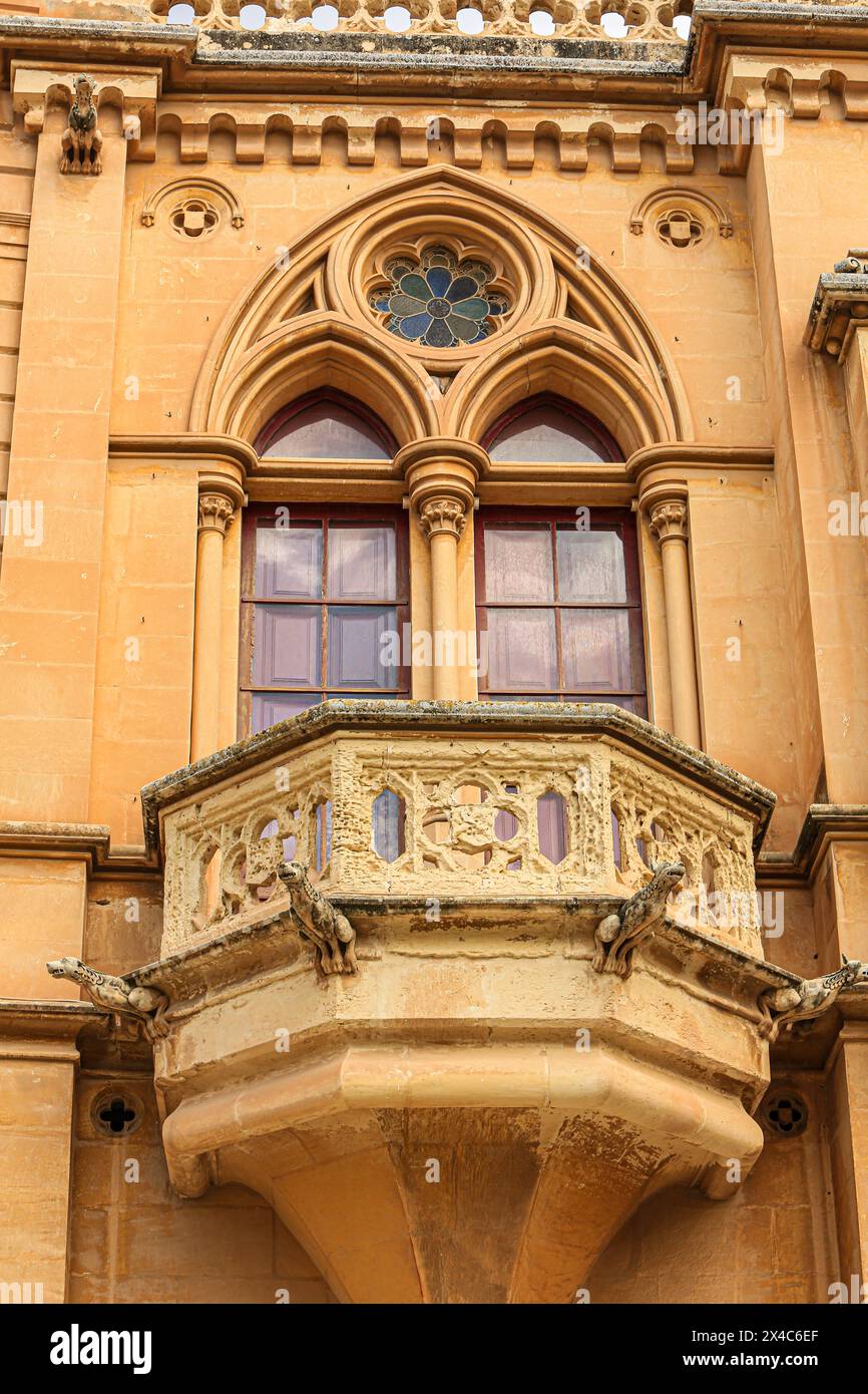 Mdina, Malta. Baroque cathedral, balconies arched stained glass windows and gargoyles Stock Photo