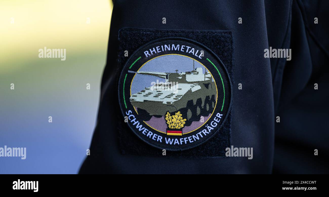 02 May 2024, Lower Saxony, Unterlüß: "Rheinmetall, Heavy Weapons Carrier" is written on the badge of an employee. The Rheinmetall armaments group has been commissioned to supply the 123 Boxer vehicles with 123 Boxer vehicles with 30mm machine guns. Photo: Philipp Schulze/dpa Stock Photo