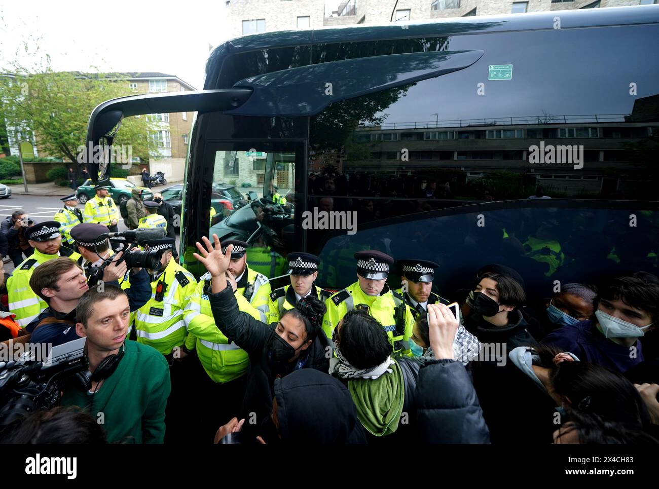 Police try and stop protesters forming a blockade around a coach which is parked near the Best Western hotel in Peckham, south London, to prevent the removal of migrants from the temporary accommodation. Picture date: Thursday May 2, 2024. Stock Photo
