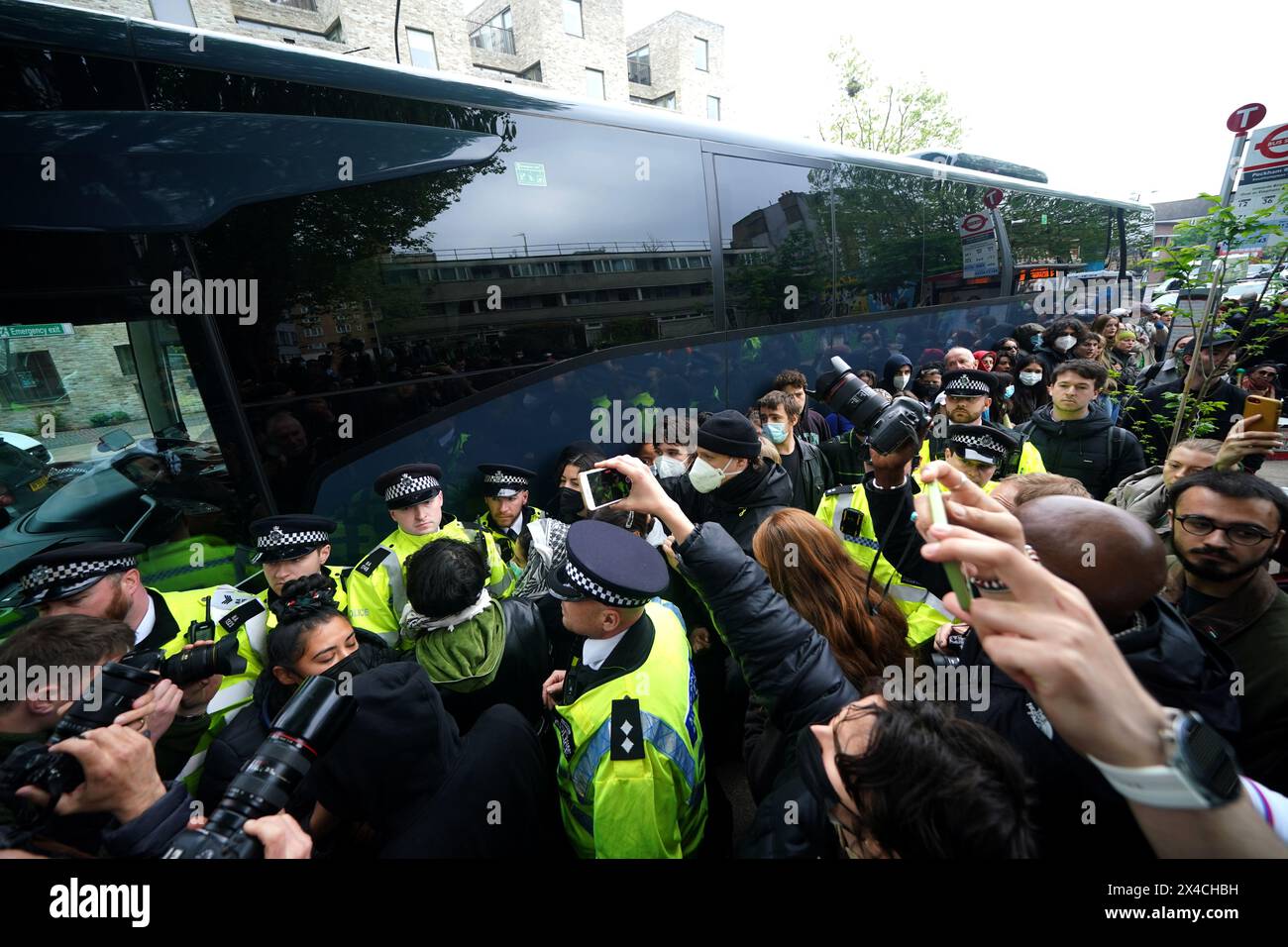 Police try and stop protesters forming a blockade around a coach which is parked near the Best Western hotel in Peckham, south London, to prevent the removal of migrants from the temporary accommodation. Picture date: Thursday May 2, 2024. Stock Photo