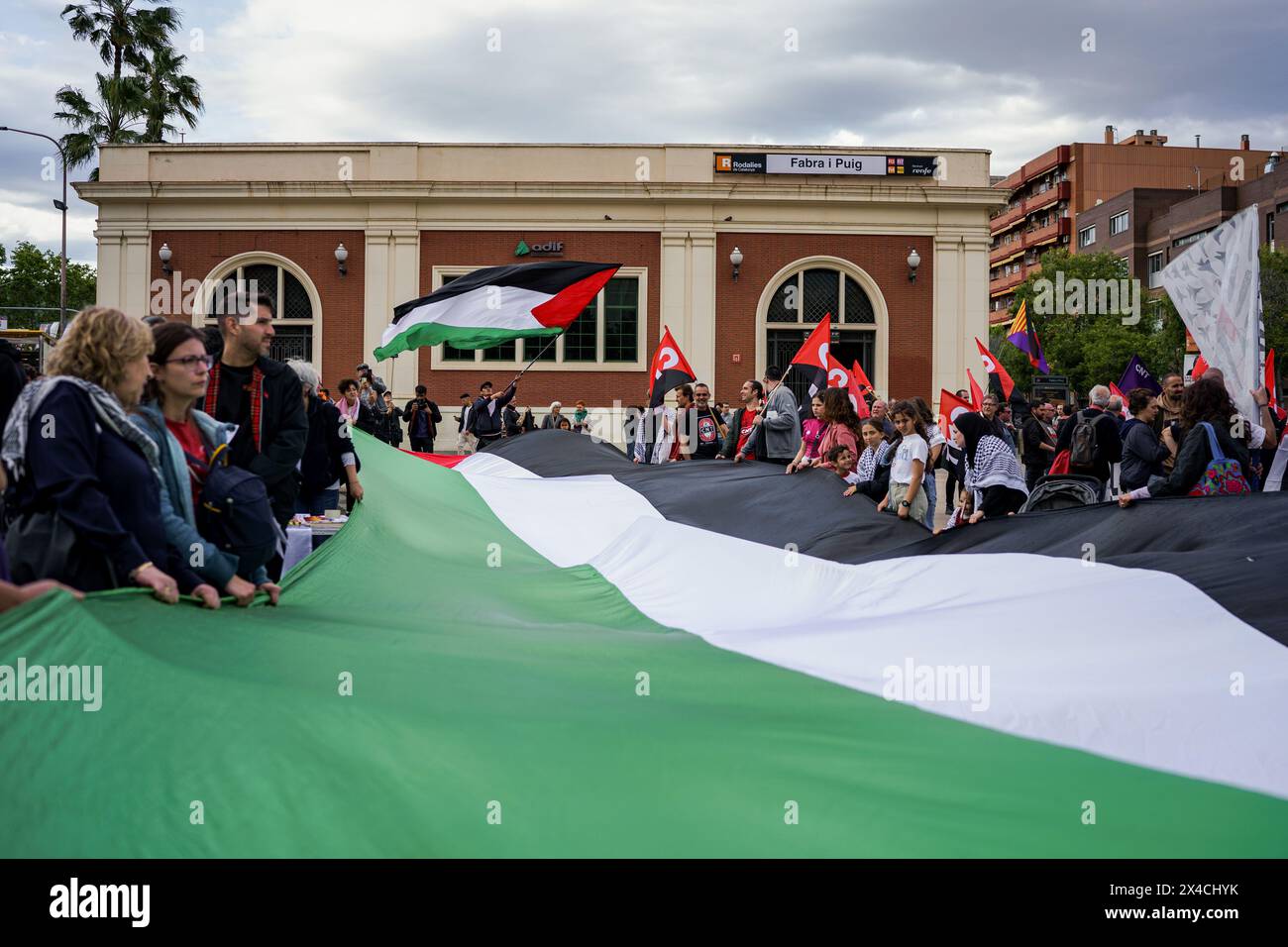 Barcelona, Spain. 01st May, 2024. Protesters hold a huge Palestinian flag during the demonstration. Thousands of people marched in Barcelona and Spain's main cities demanding better wages and working conditions on International Workers Day. (Photo by Davide Bonaldo/SOPA Images/Sipa USA) Credit: Sipa USA/Alamy Live News Stock Photo