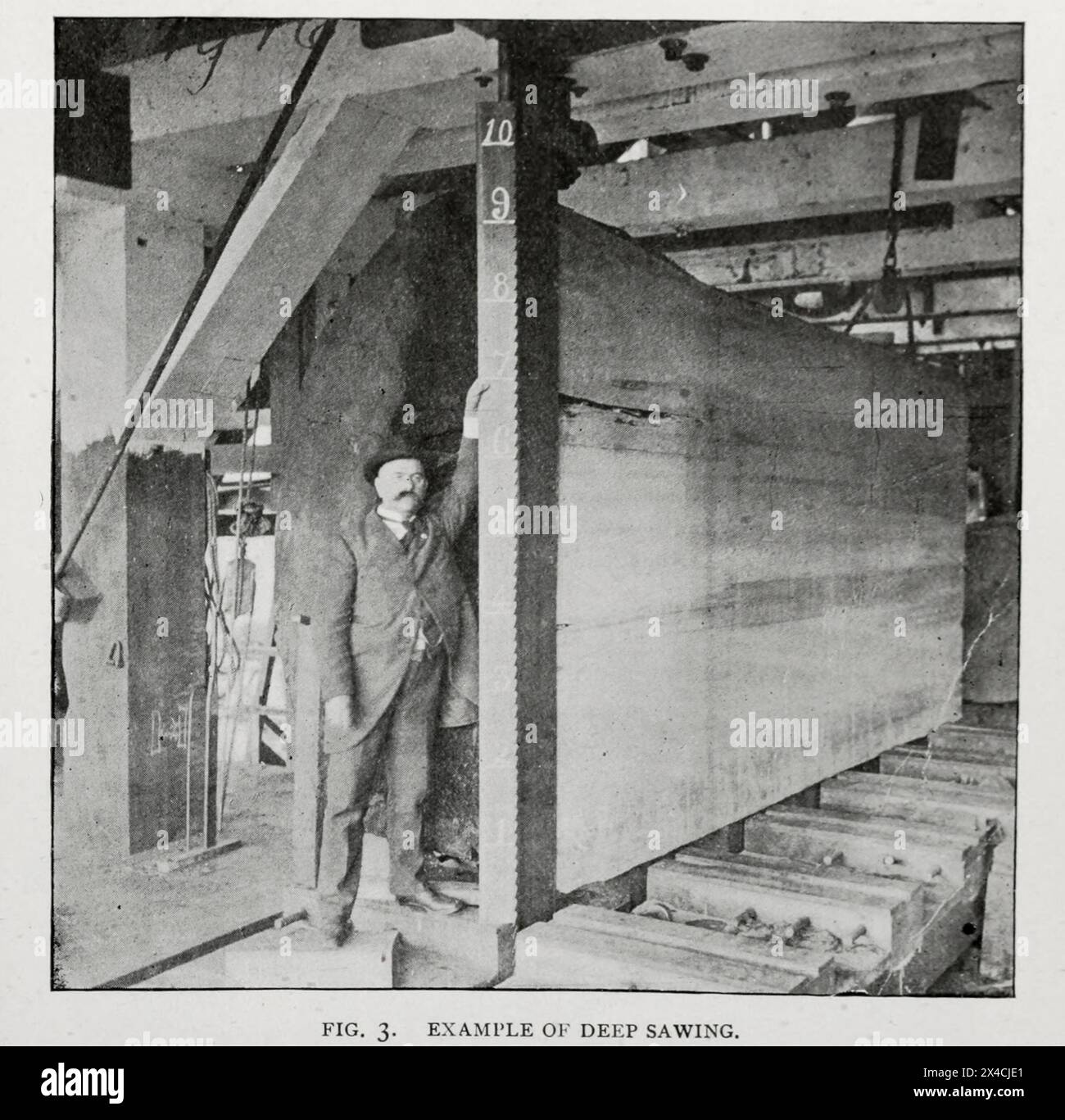 EXAMPLE OF DEEP SAWING. Showing cut, 9 ft., 6 in., deep, made with an E. P. Allis band-saw mill at Eureka. California; a fair average example of the heavy balks which can be cut only by the band-saw mill. Before the introduction of band-saws there was great waste of valuable redwood lumber on the Pacific Coast, the logs often requiring to be split by charges of blasting-powder before they could be handled by the circular saws. from the Article THE DEVELOPMENT OF WOOD-WORKING MACHINERY. By John Richards. from The Engineering Magazine Devoted to Industrial Progress Volume XVI October 1898 - Marc Stock Photo