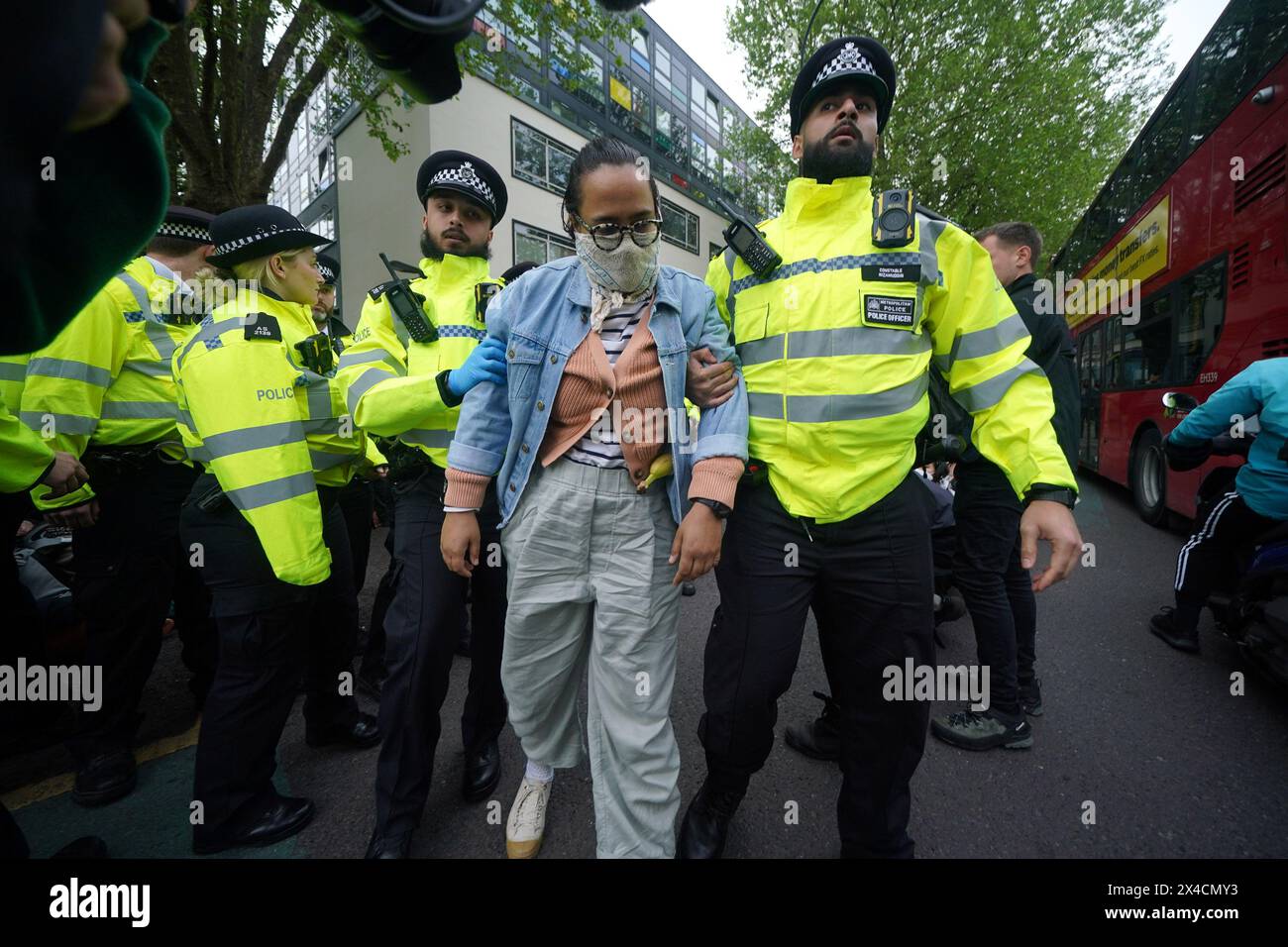 Police remove a protester after demonstrators formed a blockade around a coach which is parked near the Best Western hotel in Peckham, south London, to prevent the removal of migrants from the temporary accommodation. Picture date: Thursday May 2, 2024. Stock Photo