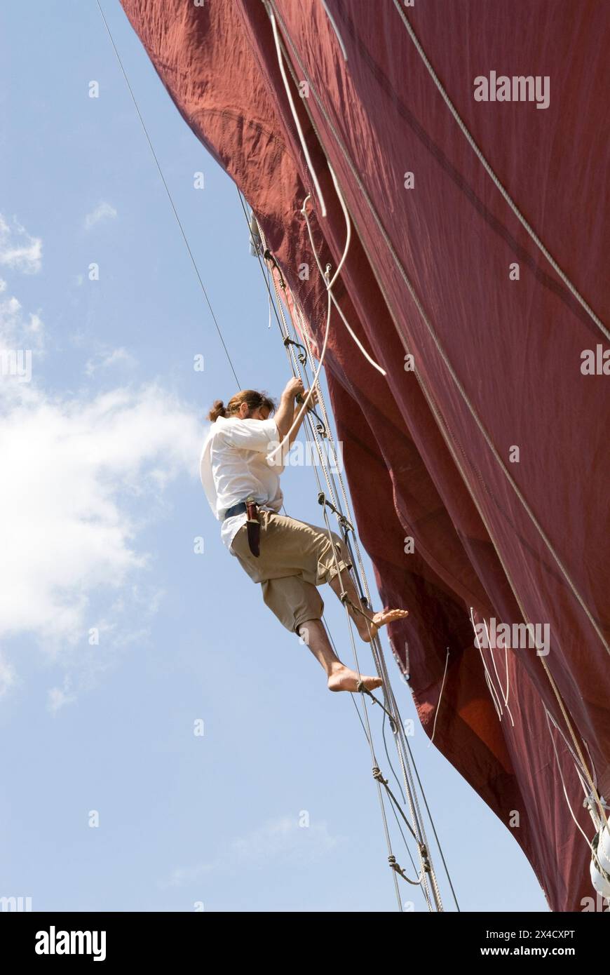Stock photo of pirate climbing rope ladder on Jolly Rover tall ship