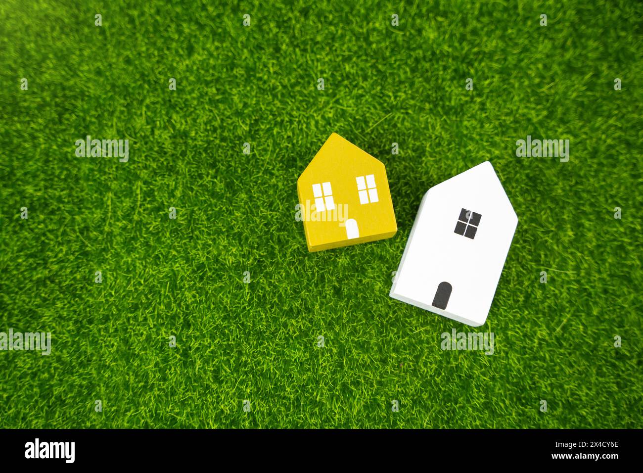 Two houses on the grass. Environmental friendliness and autonomy of housing. High energy saving technologies, in harmony with nature. Spring and summe Stock Photo