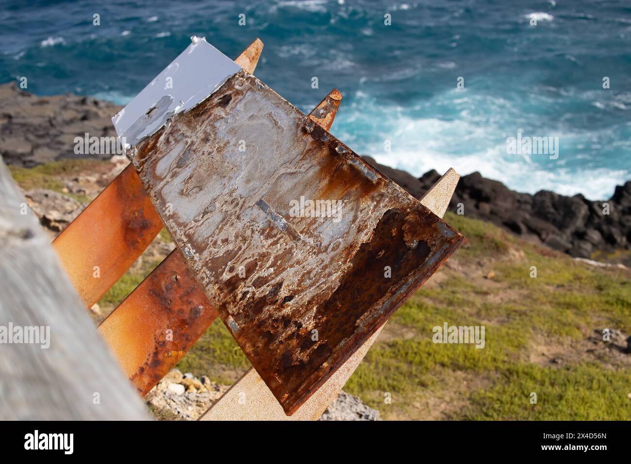 The symbol of corrosion, a sheet of iron, metal, covered with rust, against the background of the blue sea Stock Photo