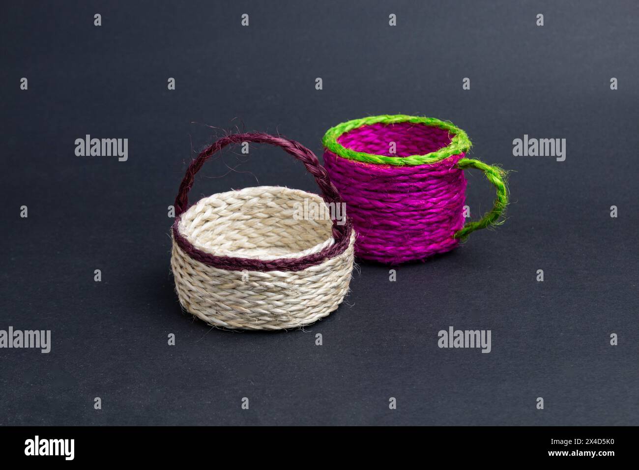 a pair of empty jute products. bucket and cup on black background. Stock Photo