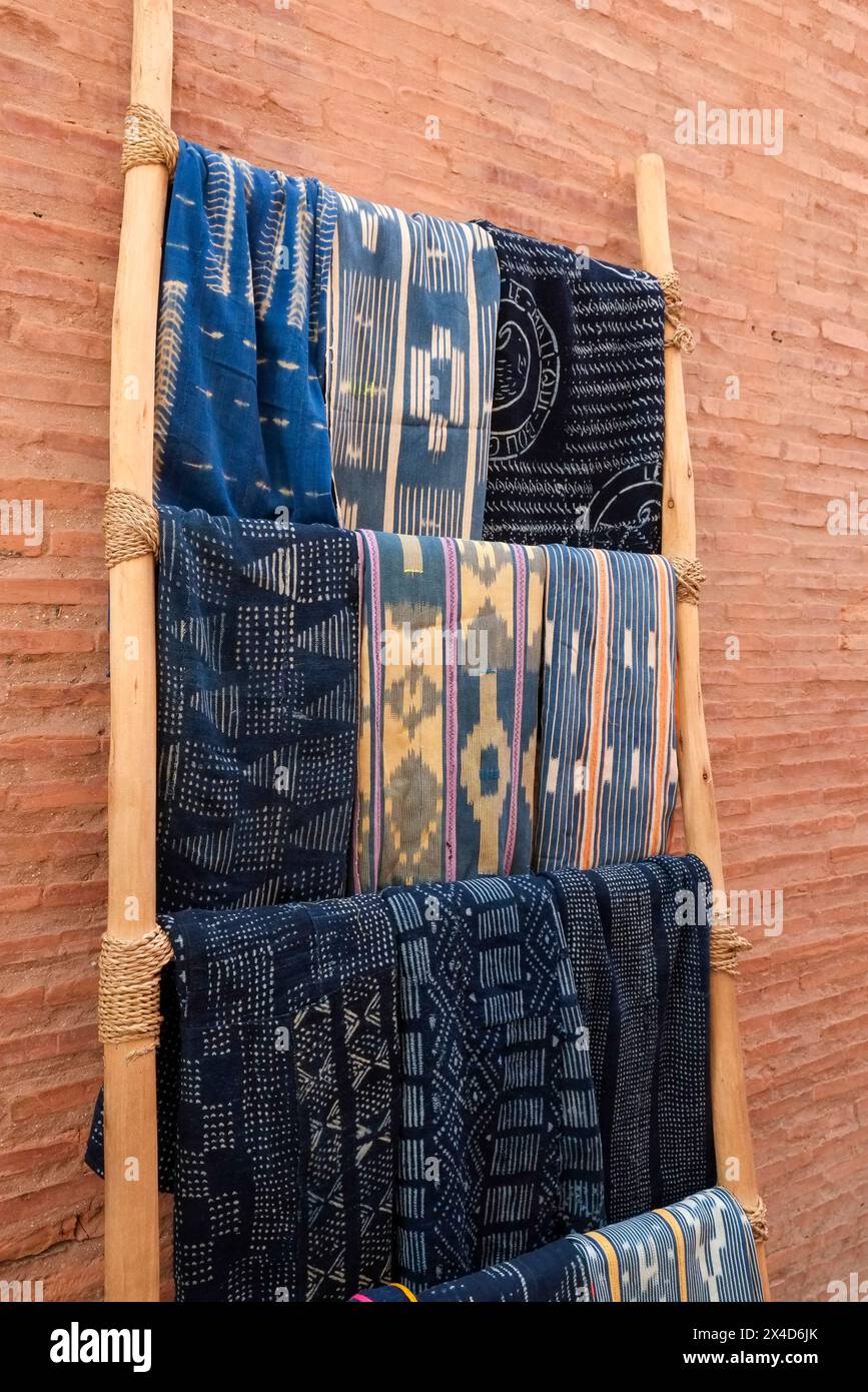 Marrakech, Morocco. Indigo dyed textiles hanging on a ladder for sale in the medina Stock Photo