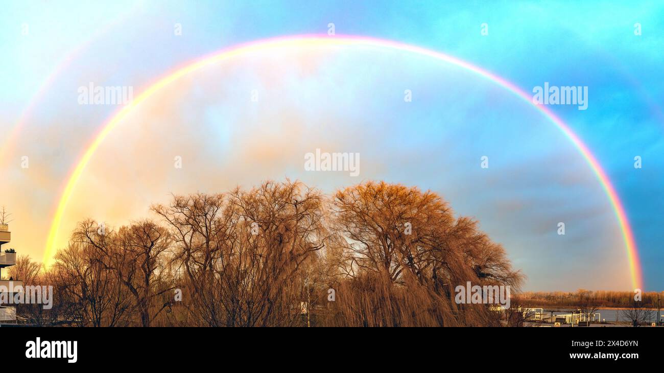half circle rain bow above the riparian forest at the river Danube at Tulln, Austria Stock Photo