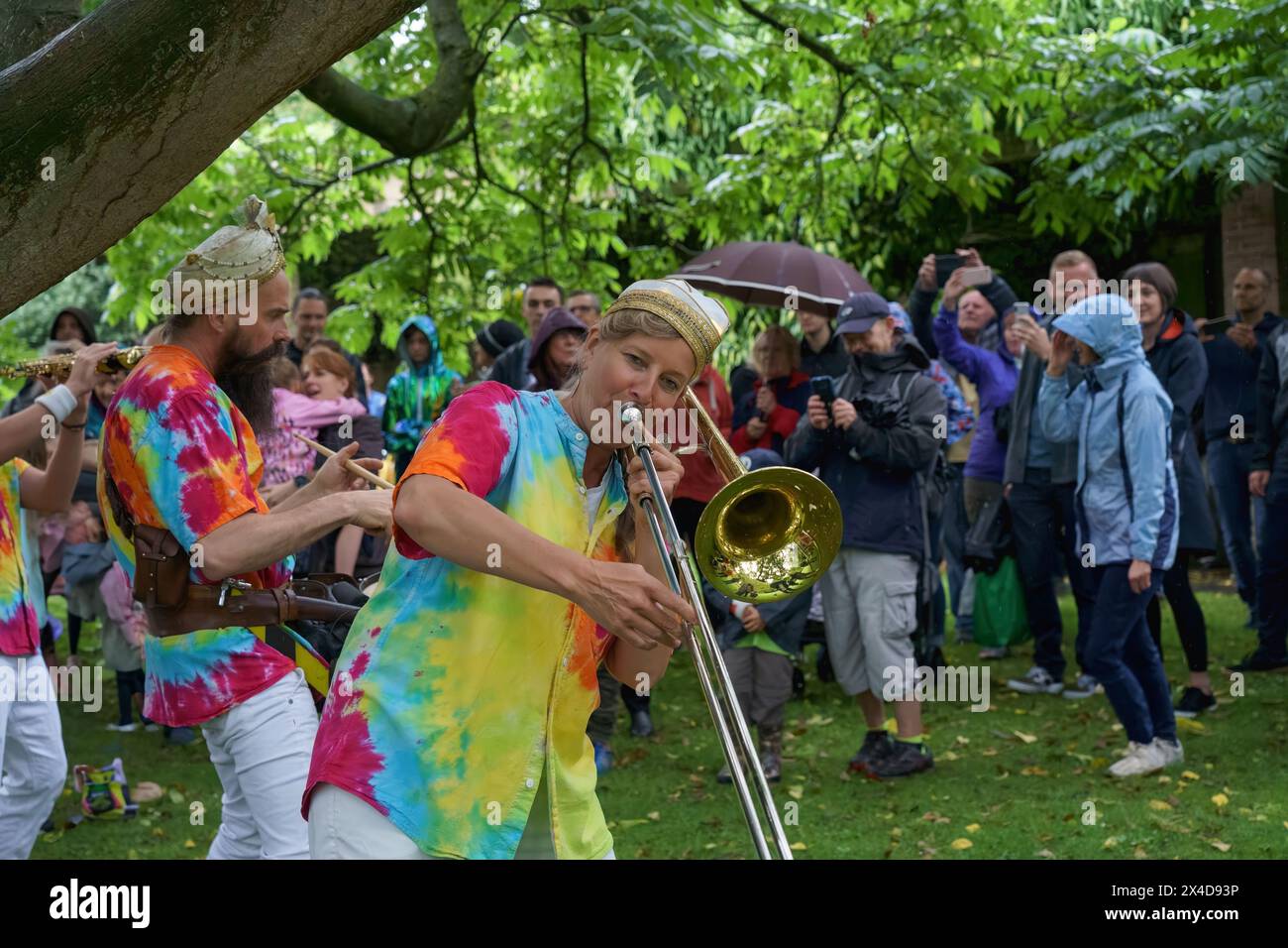 Under the shade of a leafy tree, a varied audience listens to Mr ...