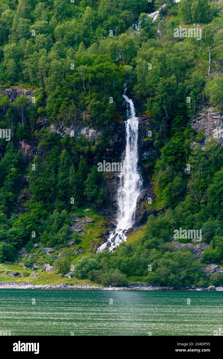 A waterfall plunges off sheer cliffs into Geirangerfjord. Geiranger, Norway. Stock Photo