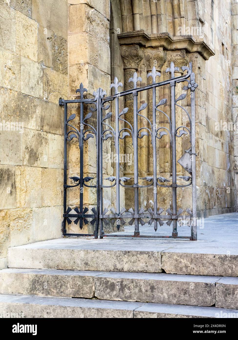 Iron gate on the side entrance of the Coimbra Old Cathedral. Stock Photo