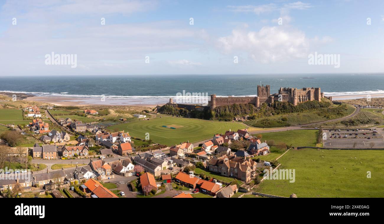 BAMBURGH CASTLE, NORTHUMBERLAND, UK - APRIL 23, 2024.  Aerial landscape panorama view of Bamburgh castle and village which is a popular tourist destin Stock Photo