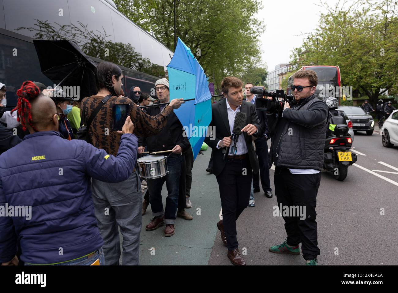 A coach sent to collect asylum seekers and take them to the Bibby Stockholm barge surrounded by protesters in Peckham south London England, UK Stock Photo