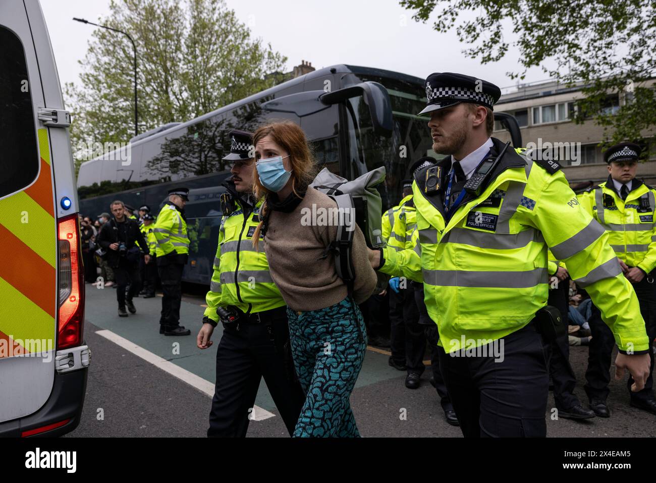 A coach sent to collect asylum seekers and take them to the Bibby Stockholm barge surrounded by protesters in Peckham south London England, UK Stock Photo