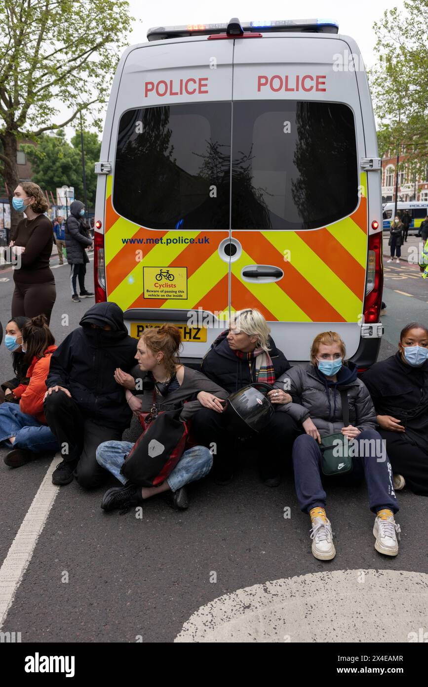 A coach sent to collect asylum seekers and take them to the Bibby Stockholm barge surrounded by protesters in Peckham south London England, UK Stock Photo