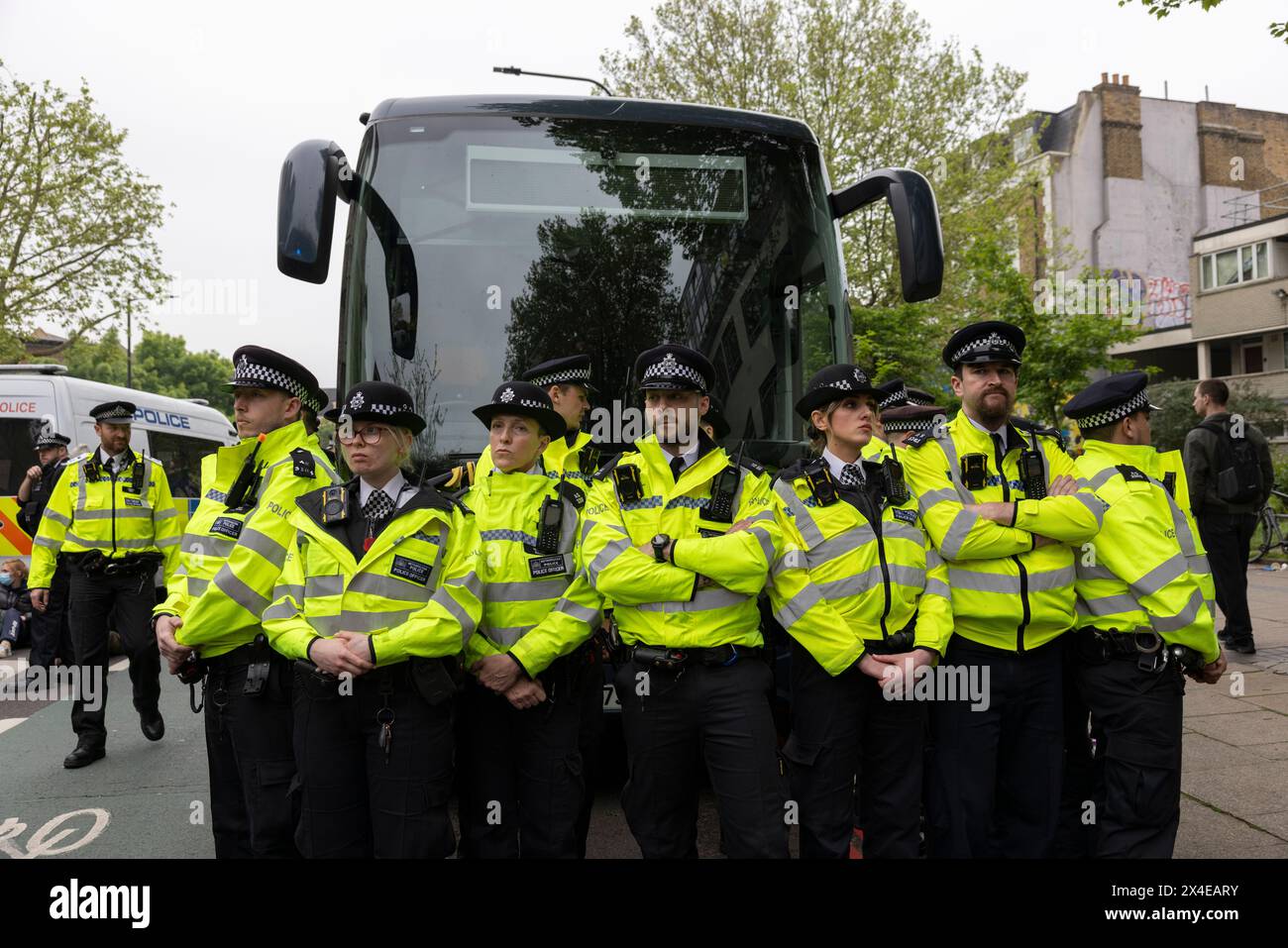 A coach sent to collect asylum seekers and take them to the Bibby Stockholm barge surrounded by protesters in Peckham south London England, UK Stock Photo