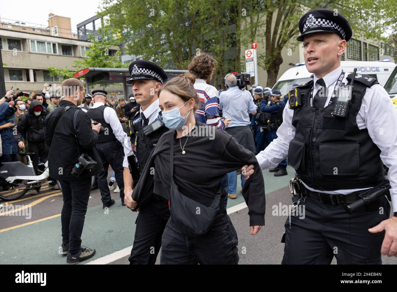 A coach sent to collect asylum seekers and take them to the Bibby Stockholm barge surrounded by protesters in Peckham south London England, UK Stock Photo