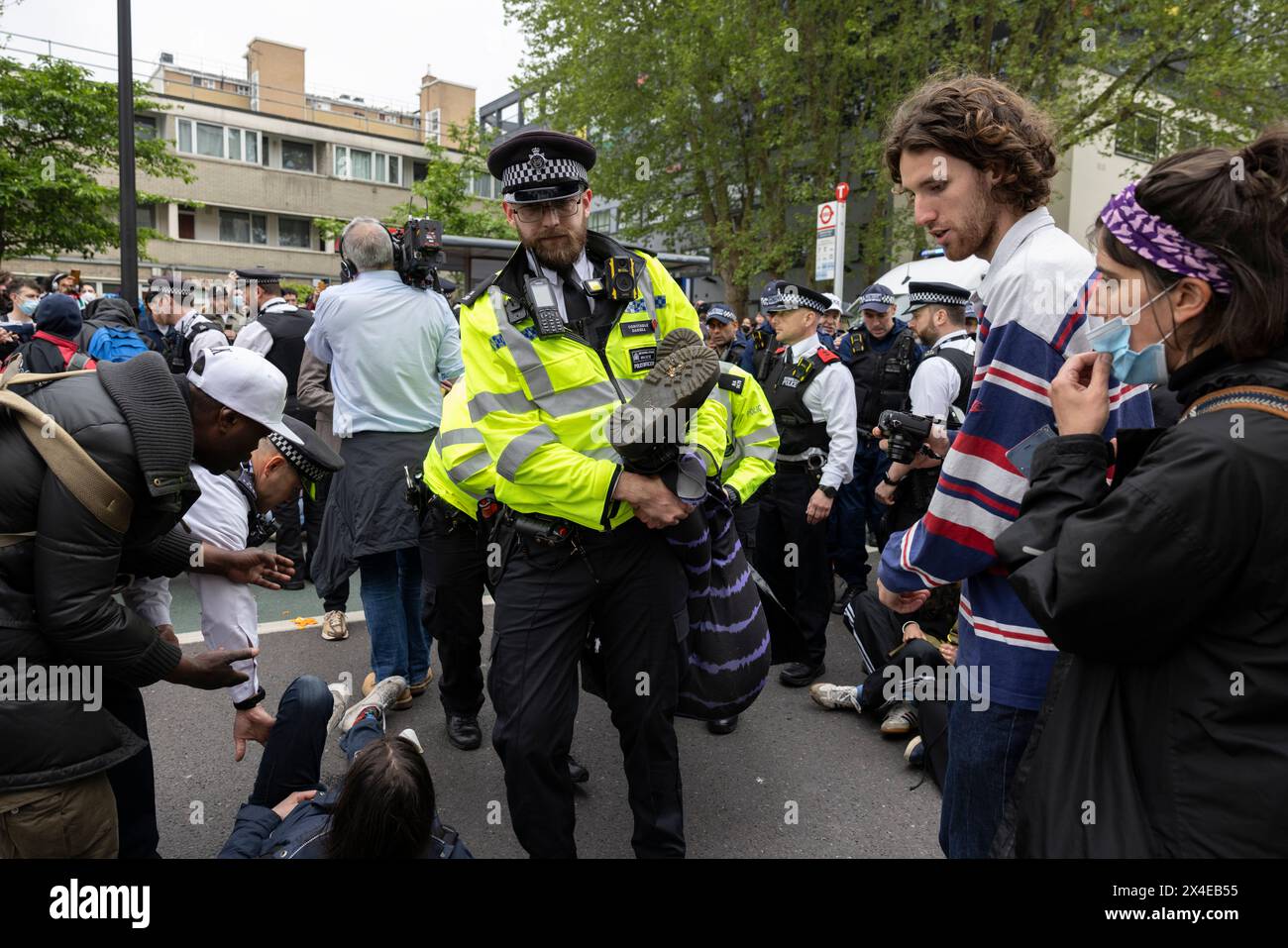 A coach sent to collect asylum seekers and take them to the Bibby Stockholm barge surrounded by protesters in Peckham south London England, UK Stock Photo