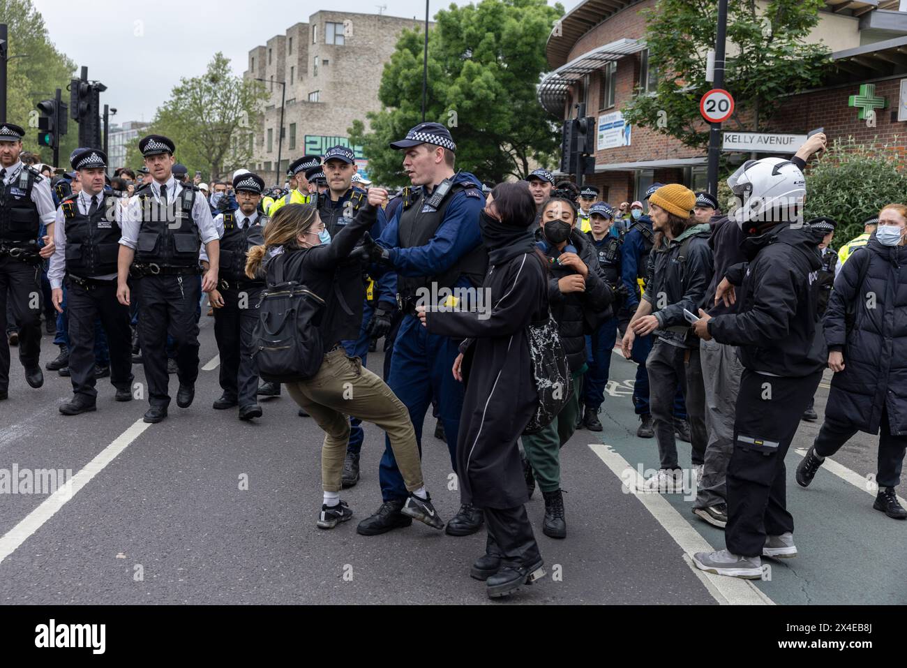 A coach sent to collect asylum seekers and take them to the Bibby Stockholm barge surrounded by protesters in Peckham south London England, UK Stock Photo