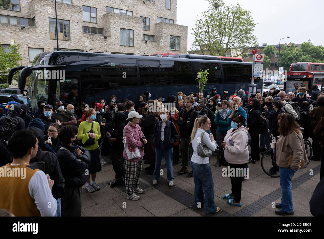 A coach sent to collect asylum seekers and take them to the Bibby Stockholm barge surrounded by protesters in Peckham south London England, UK Stock Photo