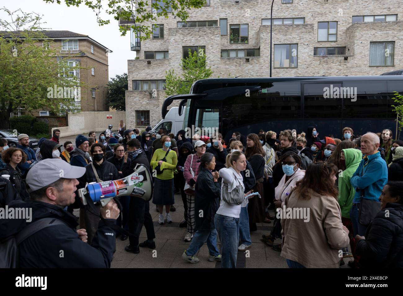 A coach sent to collect asylum seekers and take them to the Bibby Stockholm barge surrounded by protesters in Peckham south London England, UK Stock Photo