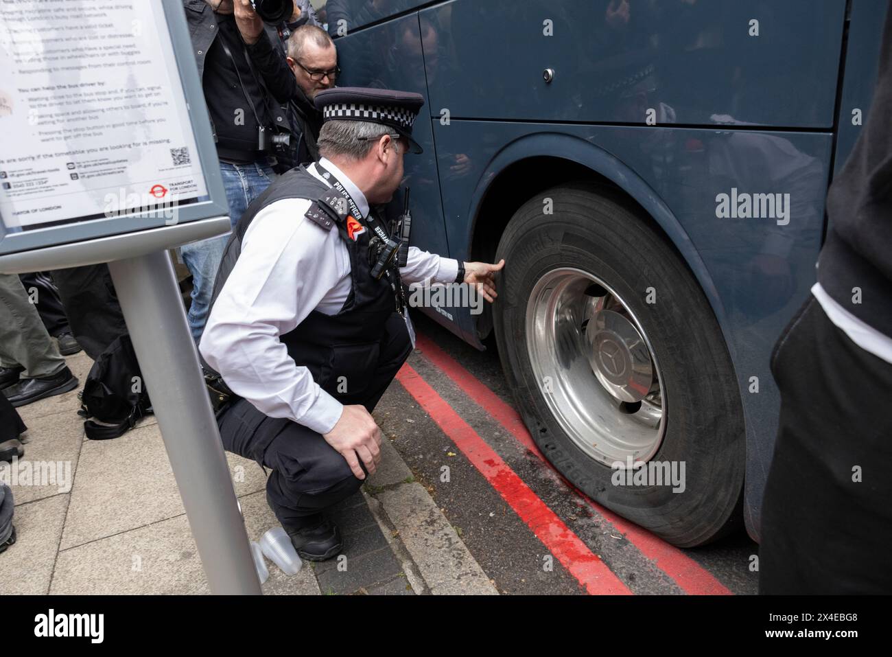 A coach sent to collect asylum seekers and take them to the Bibby Stockholm barge surrounded by protesters in Peckham south London England, UK Stock Photo