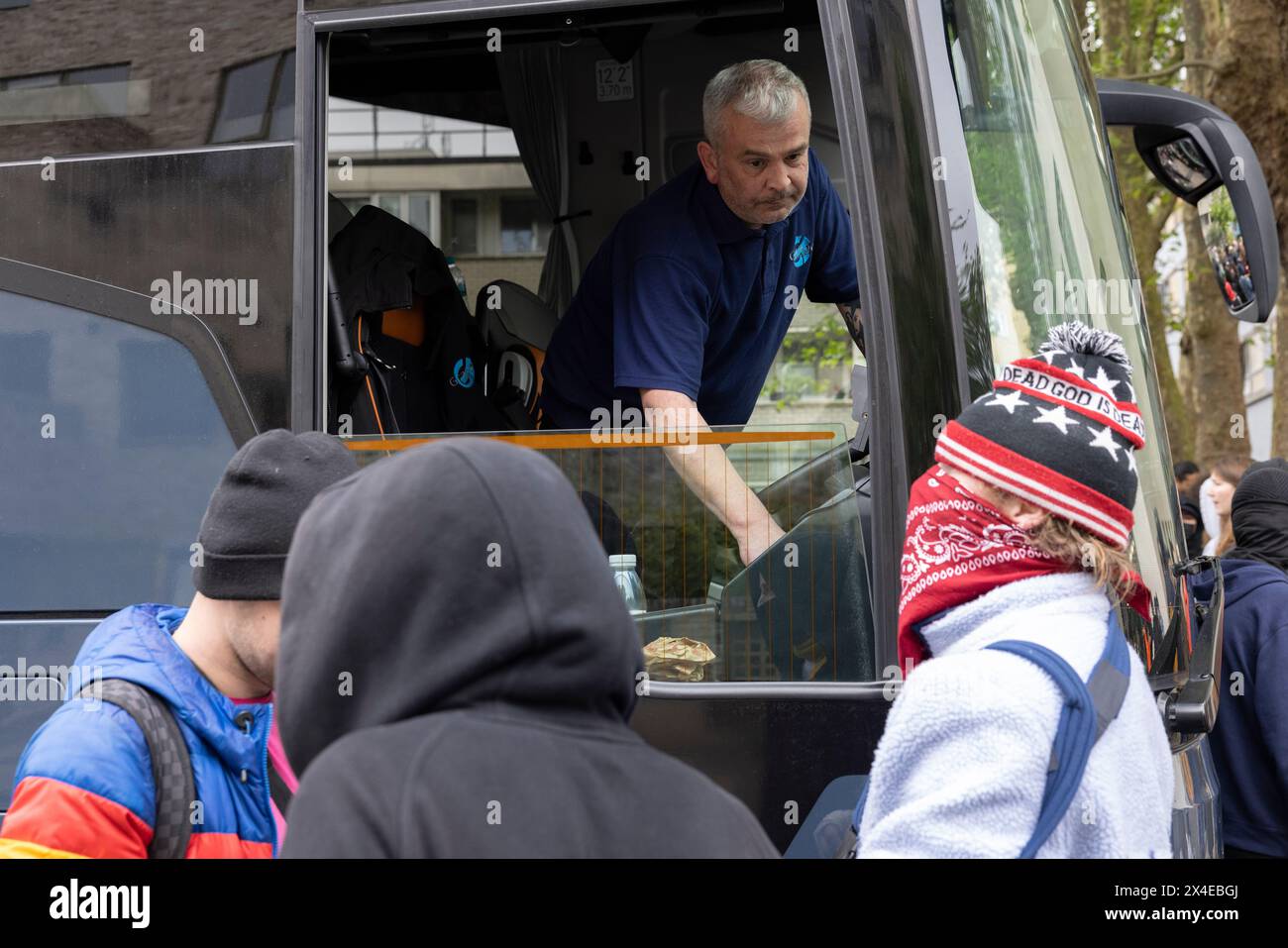 A coach sent to collect asylum seekers and take them to the Bibby Stockholm barge surrounded by protesters in Peckham south London England, UK Stock Photo