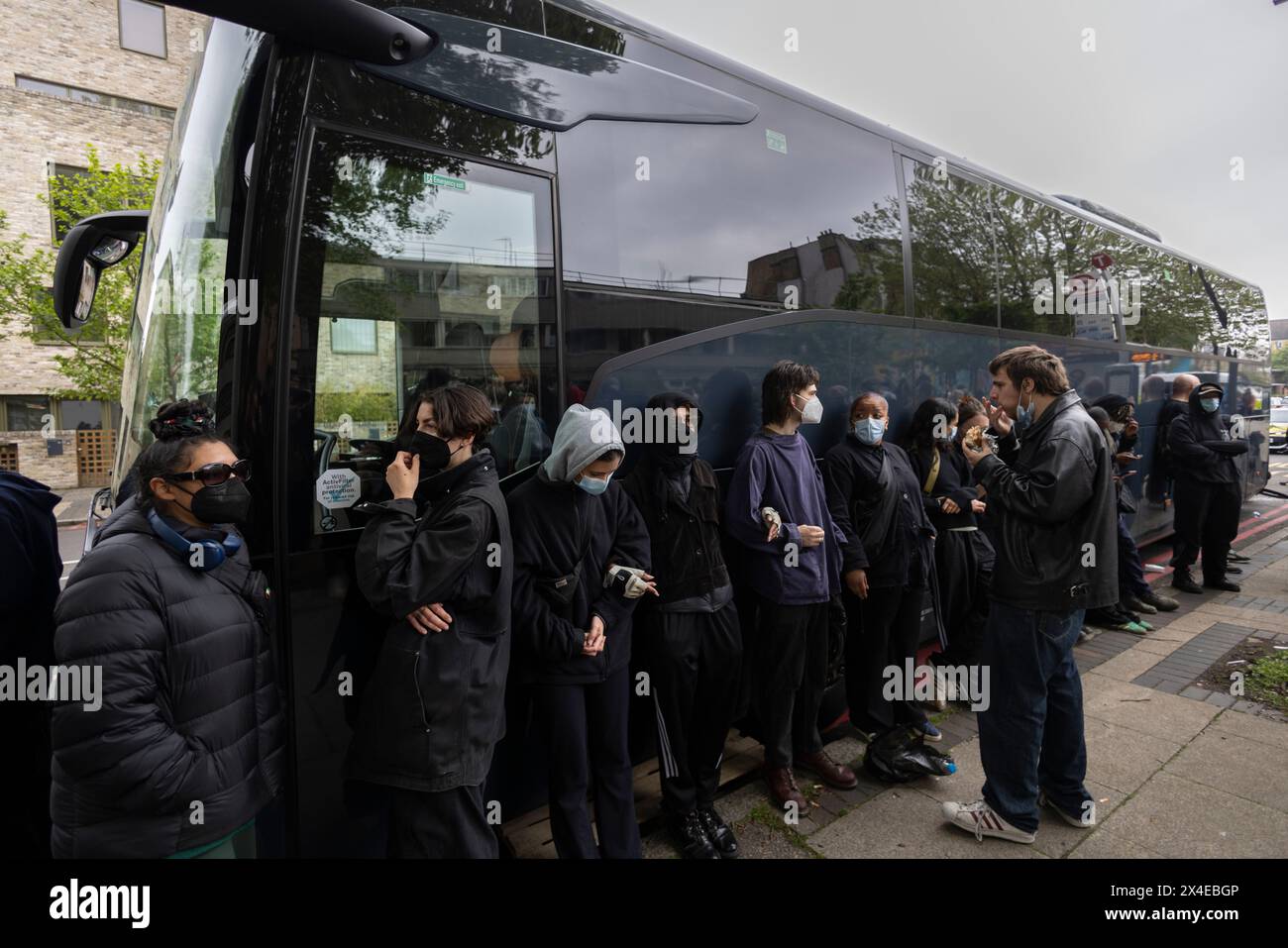 A coach sent to collect asylum seekers and take them to the Bibby Stockholm barge surrounded by protesters in Peckham south London England, UK Stock Photo