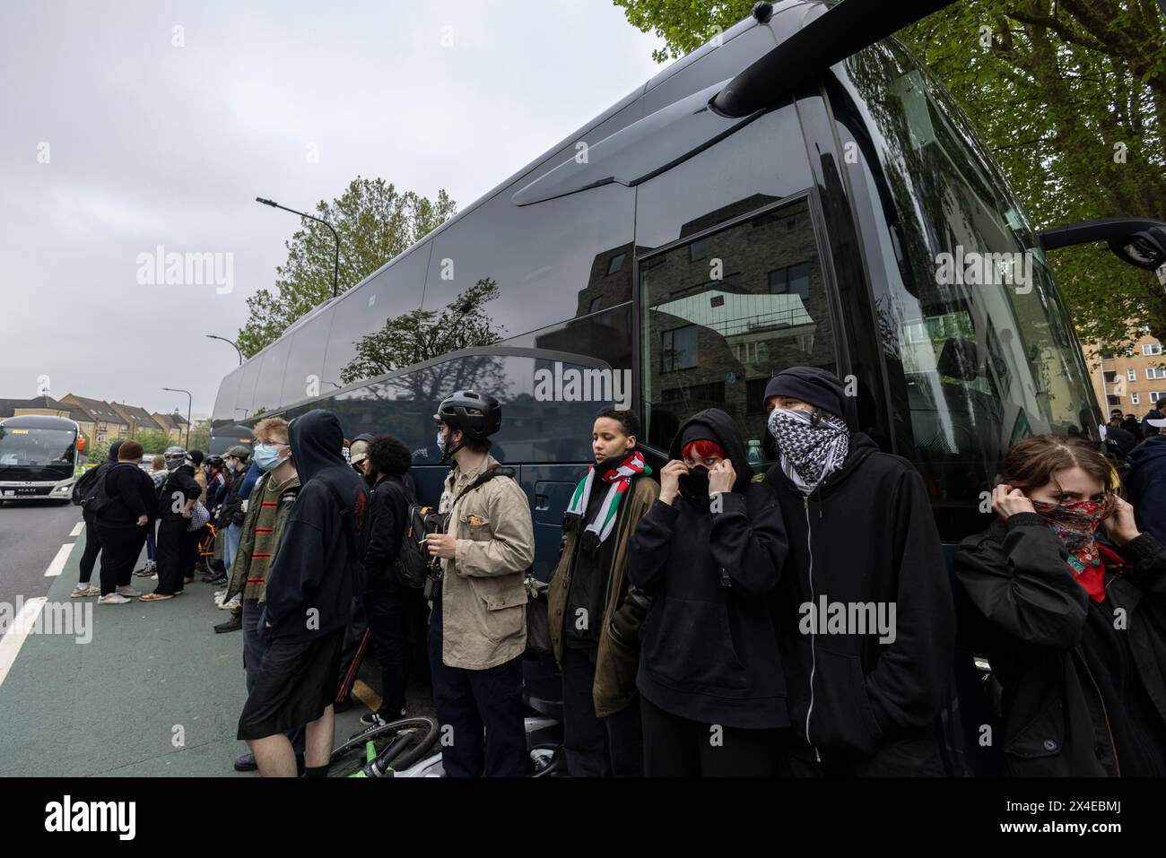 A coach sent to collect asylum seekers and take them to the Bibby Stockholm barge surrounded by protesters in Peckham south London England, UK Stock Photo