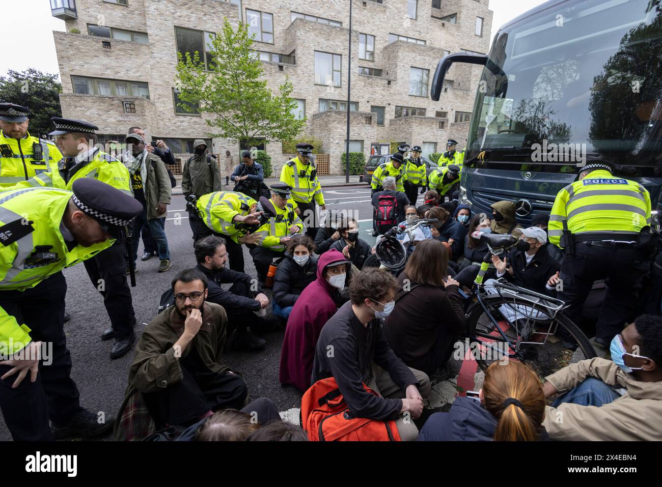 A coach sent to collect asylum seekers and take them to the Bibby Stockholm barge surrounded by protesters in Peckham south London England, UK Stock Photo