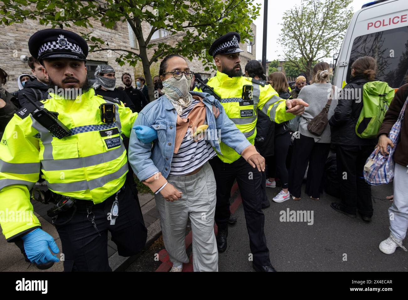 A coach sent to collect asylum seekers and take them to the Bibby Stockholm barge surrounded by protesters in Peckham south London England, UK Stock Photo