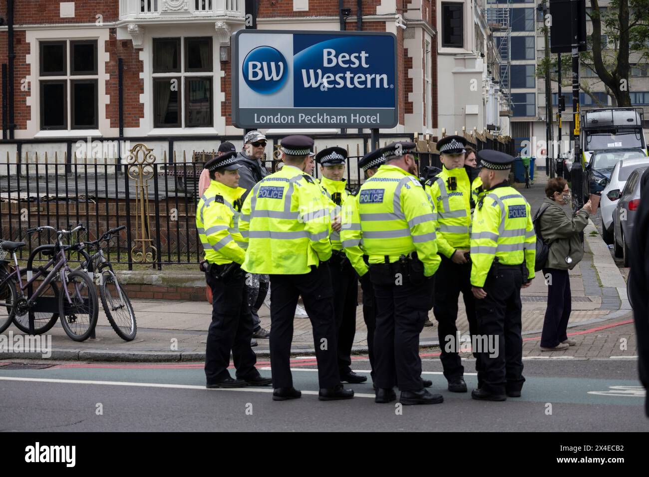 A coach sent to collect asylum seekers and take them to the Bibby Stockholm barge surrounded by protesters in Peckham south London England, UK Stock Photo