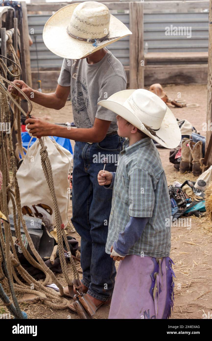 Galisteo, New Mexico, USA. Cowboy teaching younger cowboy 'the ropes ...