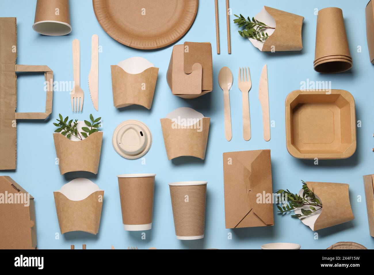 Flat lay composition with eco friendly food packagings and twigs on light blue background Stock Photo