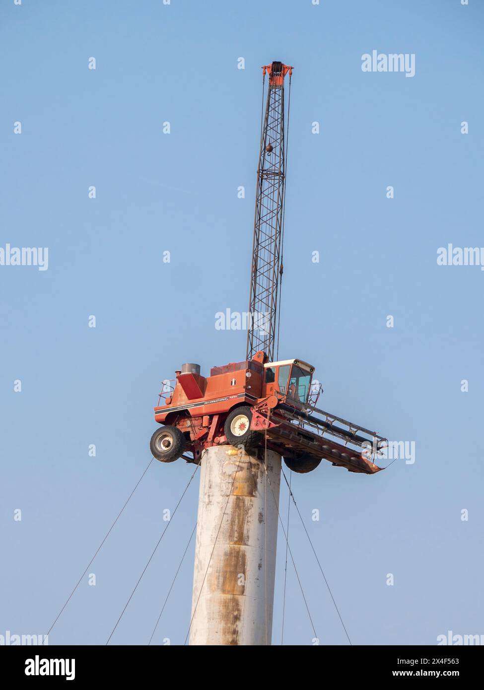 Red combine sits on pole held in place by guide wires in the Palouse ...