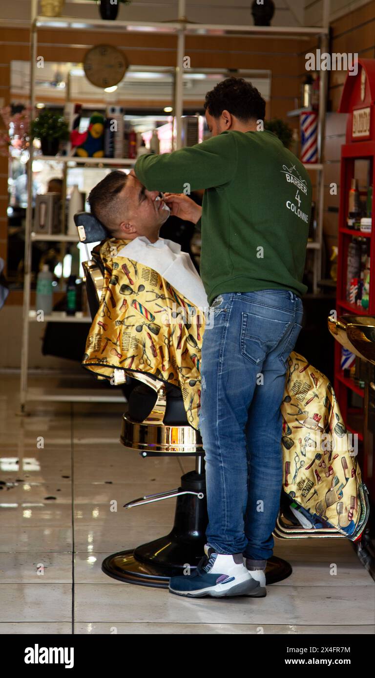 Barber giving haircut to customer inside Stock Photo