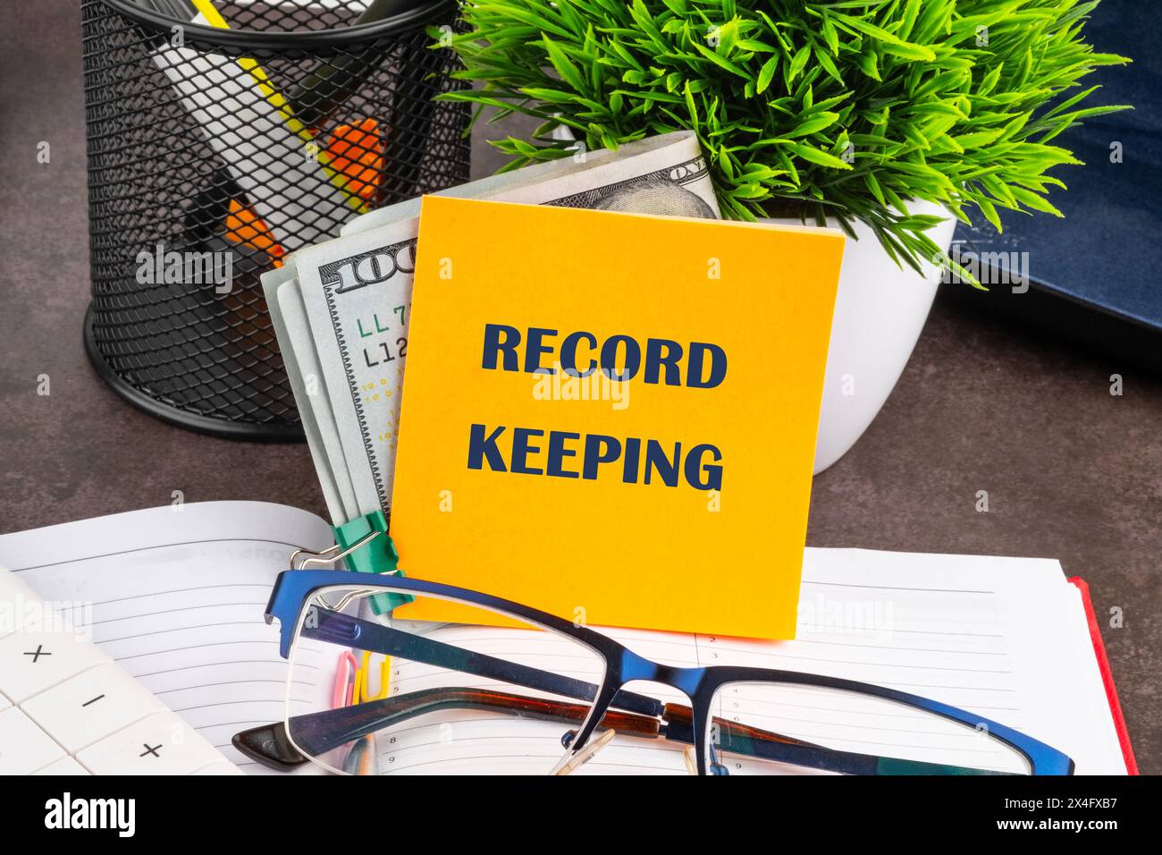 Record keeping text concept on a yellow sticker with dollars, on the desktop of a businessman, manager Stock Photo