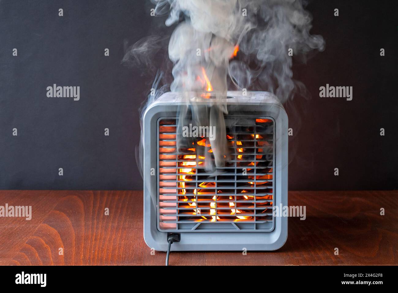 Air purifier burns with fire, flames and sparks, black smoke. The cause of the fire in the apartment, a short circuit, faulty equipment. Stock Photo