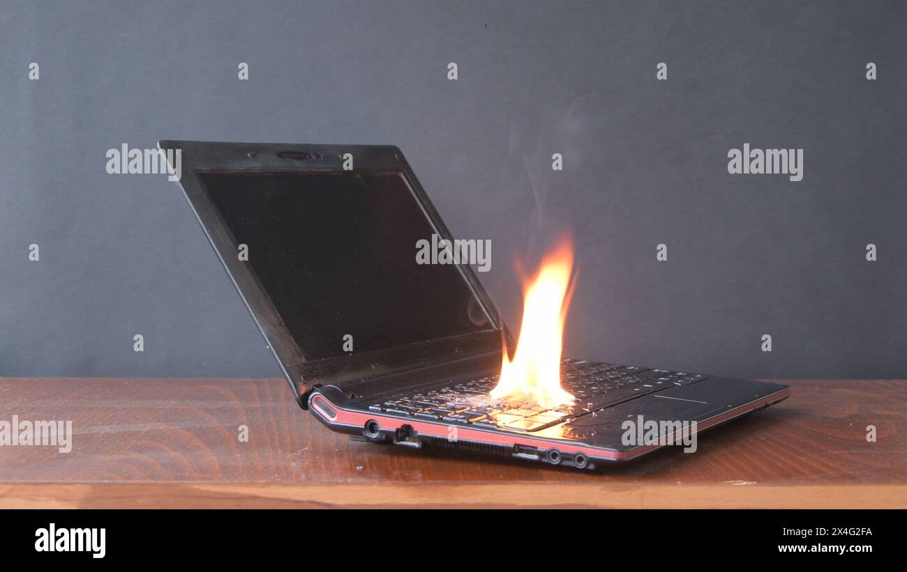 In the room on the table the laptop caught fire, the ignition of the battery and contacts, a short circuit. Fire safety system. Stock Photo