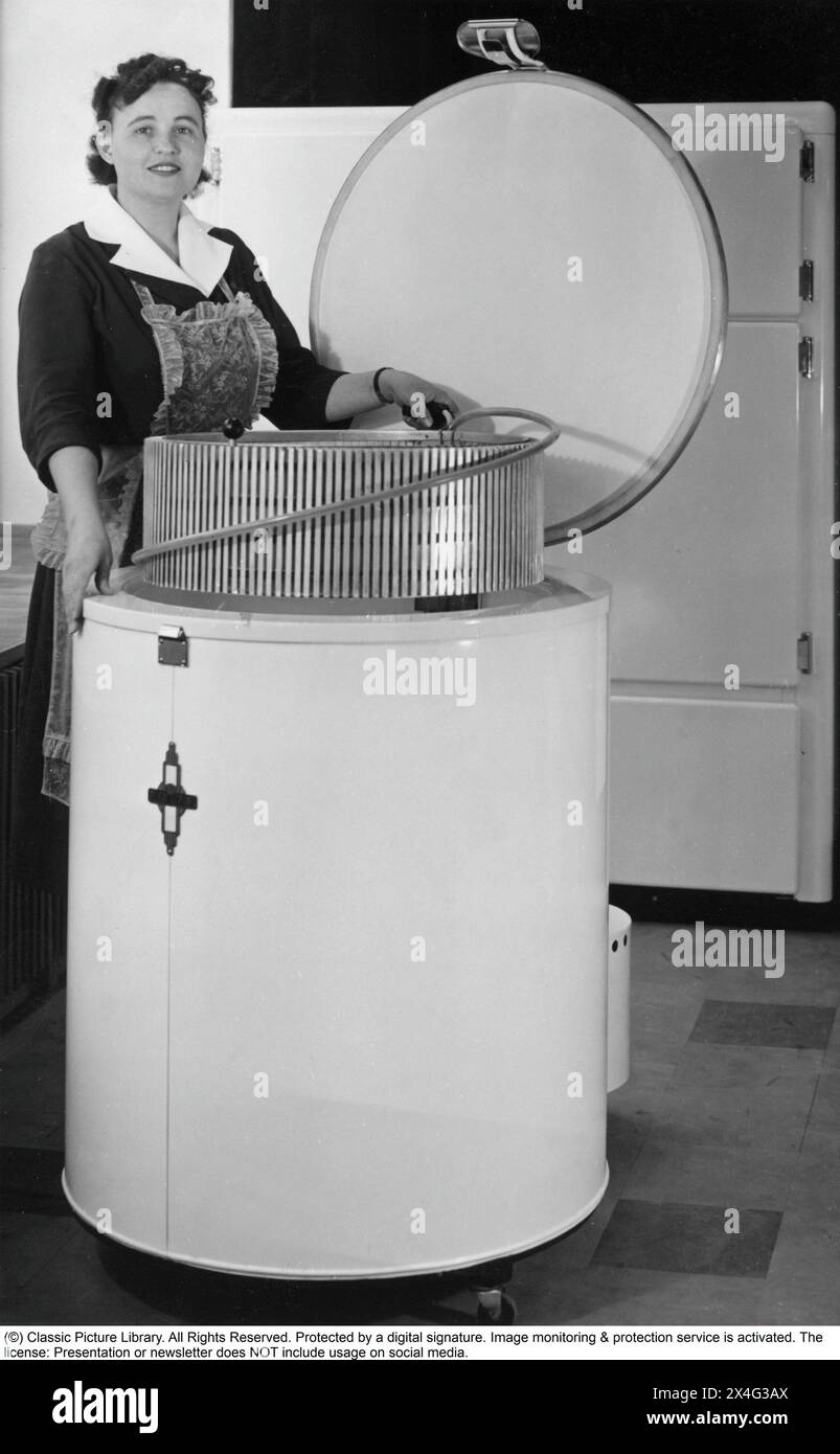 A woman at a freezer of an odd design and round form 1955. Deep-frozen food would be the start of a revolution in household habits and food storage. Many were sceptical, and especially canned food manufacturers considered frozen food to be a passing trend. Stock Photo