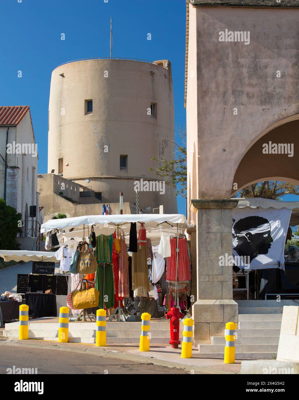 Bonifacio, Corse-du-Sud, Corsica, France. View from Place de l'Europe to the Torrione, a restored 15th century watchtower, market stall in foreground. Stock Photo