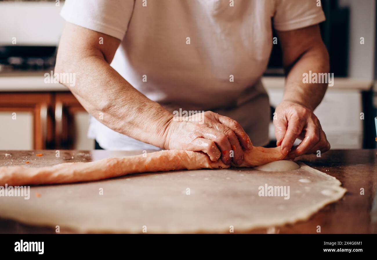 Person preparing pastries from dough with pumpkin Stock Photo