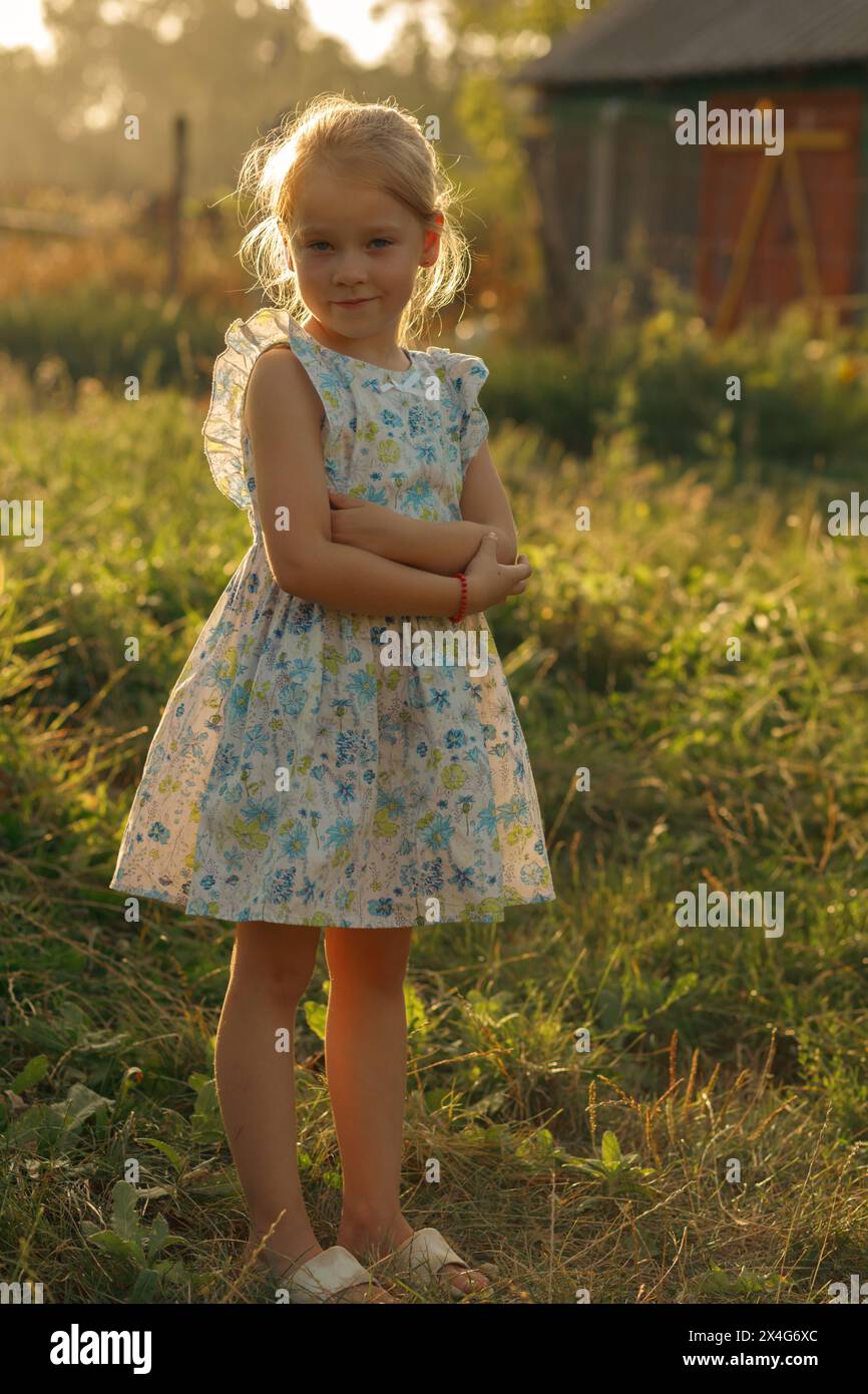 Little girl in floral dress at the countryside Stock Photo