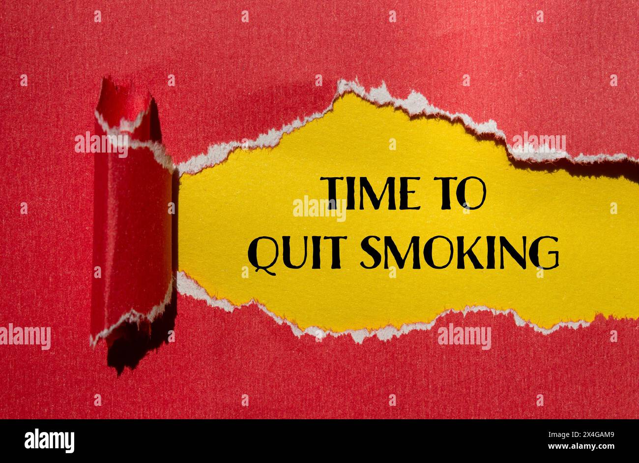 Time to quit smoking words written on ripped red paper with yellow background. Conceptual time to quit smoking concept. Copy space. Stock Photo