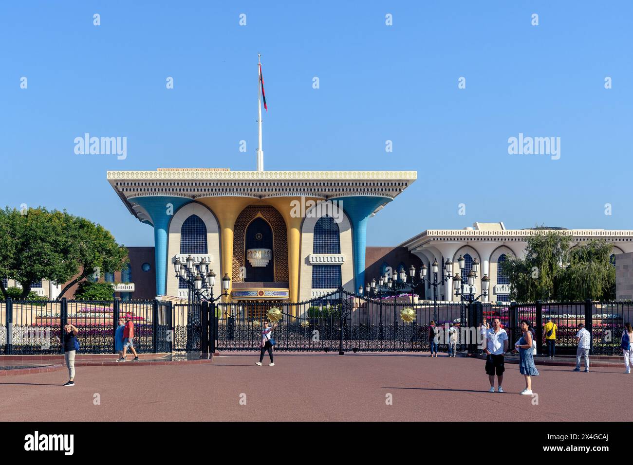 Muscat, Oman - January 2, 2024: Tourists explore the majestic Al Alam Palace square under the clear blue sky. Stock Photo