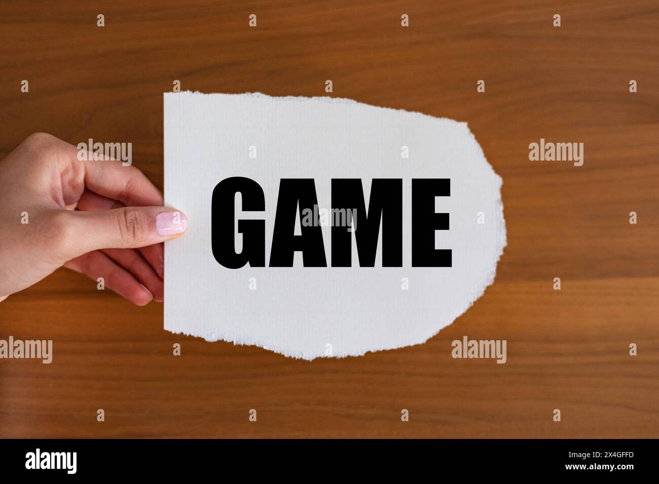 Game Game. Woman hand holds a piece of paper with a note, game. Leisure activity, playing, bingo, game show, event. note B1983 game Stock Photo
